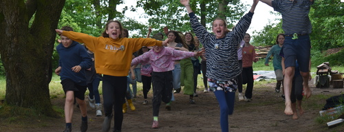 Eine Gruppe Kinder läuft mit hochgehaltenen Händen lächelnd auf die Kamera zu. 35f0558faa257ed820c932bcfd5613560bdf0953