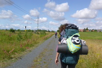 Eine Person mit vollgepacktem Rucksack wandert einen Weg entlang. 101015037425fed37025e166e94afea7da4eb0cc