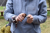 Eine Jugendliche Person macht Feuer mit Feuerstahl. 73a35d84687081b75fe332a29f2c724a49b1a7e1